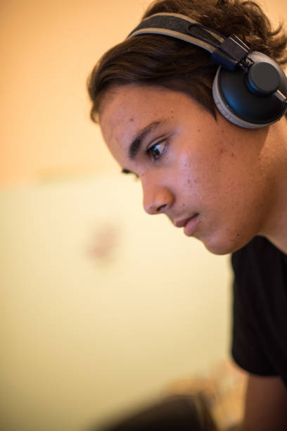 istock Teenager Boy Playing Multiplayer Video Game on Computer Wearing Headphones 1343085909