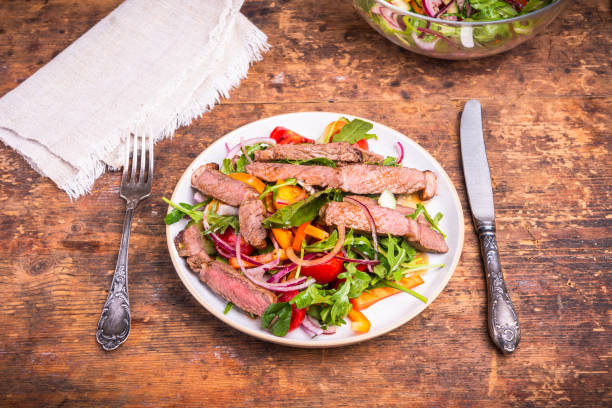 istock Light lunch - vegetable salad with pieces of beef steak on a plate 1343094873