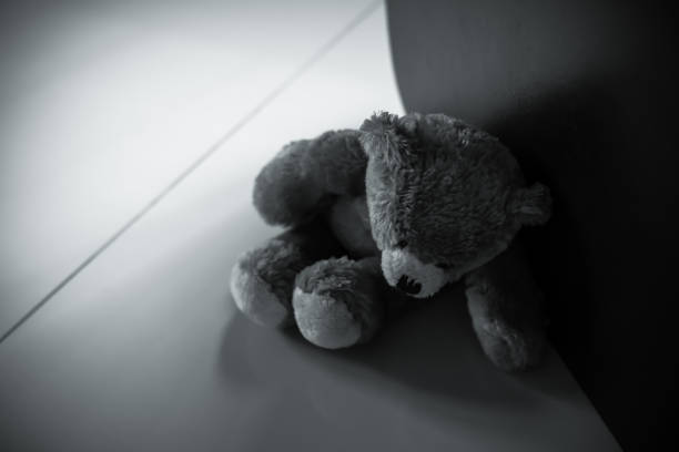 istock Alone teddy bear sitting beside wall dark black and white image. 1343096543