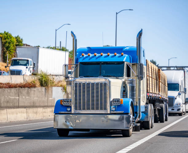 istock Big rigs classic semi trucks transporting cargo in different semi trailer running on the highway road with another traffic 1343098435