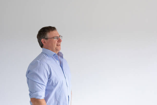 Close-up portrait of cheerful mature businessman looking at camera while standing in a modern office building