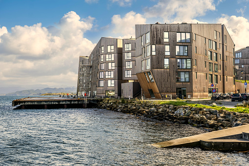 The waterfront of a modern district of Stavanger, in southern Norway, with some energy efficient residential buildings. Featuring a modern construction using wood and sustainable materials, these innovative residential buildings maintain a classic Scandinavian design in harmony with the surrounding space. The city of Stavanger is among the favorite tourist destinations for thousands of tourists who arrive with the numerous cruise ships that ply the routes of northern Europe and the Norwegian coast. Stavanger is also known for being the oil city of Norway, with the presence of many national and multinational energy companies and a museum completely dedicated to oil and its extraction. Image in High Definition format.