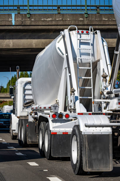 istock White day cab big rig semi truck transporting cargo in bulk conus semi trailer running on the road with heavy traffic and bridge 1343100142
