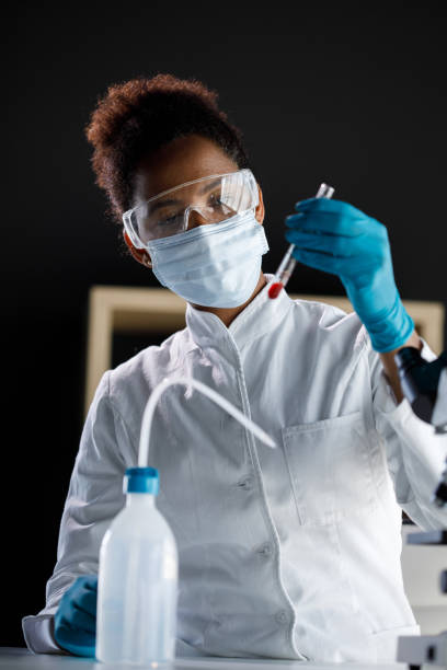istock Female scientist in protective gear analyzing blood in a test tube 1343102570