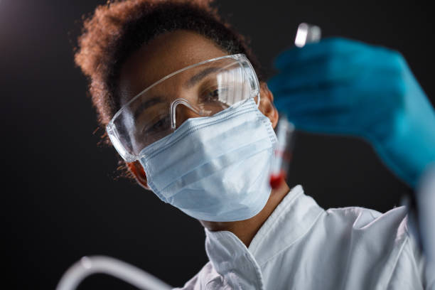 istock Headshot of female lab tech analyzing a sample she is holding in a test tube 1343102598