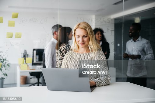 istock Happy business woman working on her computer 1343105640