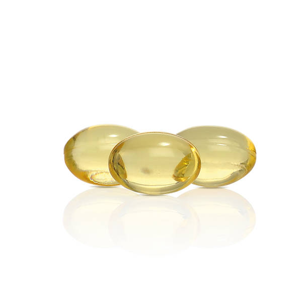 capsules jaunes avec le médicament. huile de poisson. - vitamin pill capsule vitamin e fish oil photos et images de collection