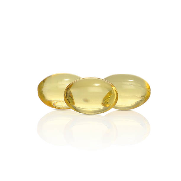 Yellow capsules with the drug. Fish oil. Yellow capsules with the drug. Fish oil. Capsules made of a gelatin soluble shell filled with a liquid medicinal substance. vitamin photos stock pictures, royalty-free photos & images