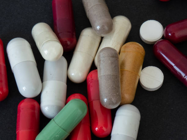 istock colored medicines on black background, closeup 1343116449