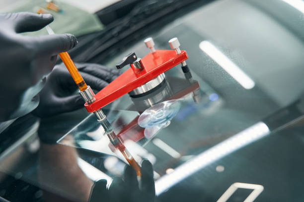 istock Serviceman in workshop fixing broken car window with vacuum filler 1343117536