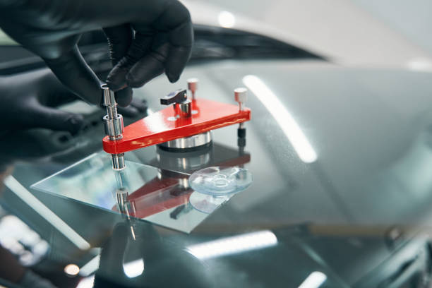 istock Closeup repair of cracked car windshield. Auto windshield crack fixing 1343117537