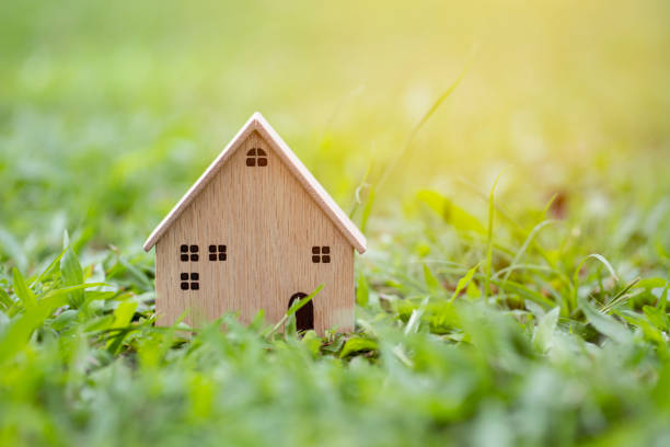 istock Closeup wood model house on grass background 1343119742