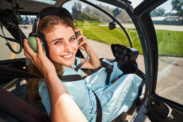 istock Smiling female pilot putting on headphones before flight 1343120500