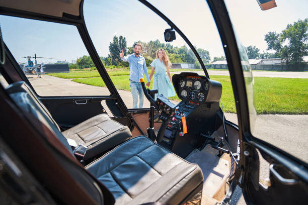 istock Joyous romantic couple looking at chopper at heliport 1343120871