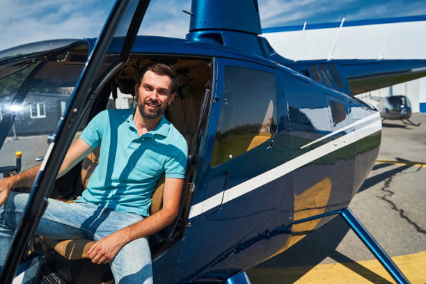Happy male pilot posing for camera before helicopter flight