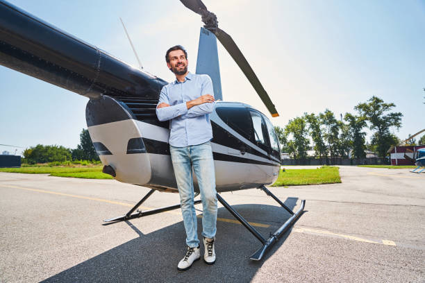 istock Cheerful man standing by chopper at heliport 1343120940