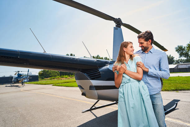 istock Happy young couple standing by private helicopter 1343120953