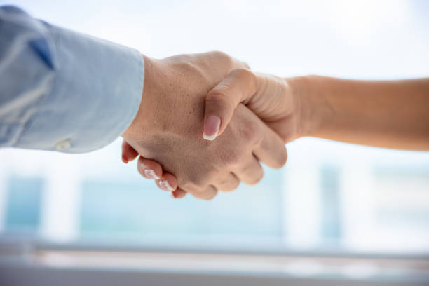 istock Close-up on handshake by the office window 1343126692