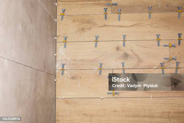 Professional Tile Laying Placing Or Taking Out Special Tile Spacersnmaintenance Repair Works Renovation In The Flat Restoration Indoors Work In Process Stock Photo - Download Image Now