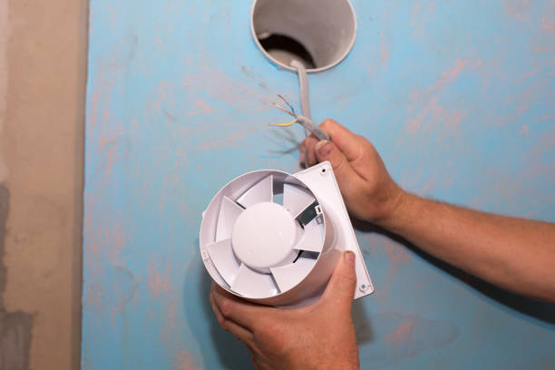 istock Man is installing the wall bathroom fan vent. Restoration process. Wires in hands. Maintenance repair works renovation in the flat. 1343130220