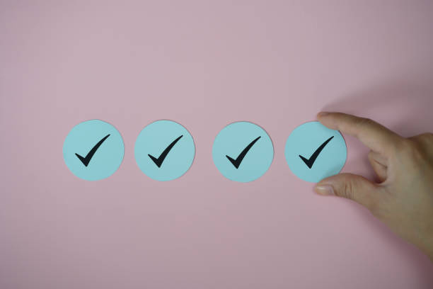 istock Hand holding check mark icon paper cut on pink background 1343130887