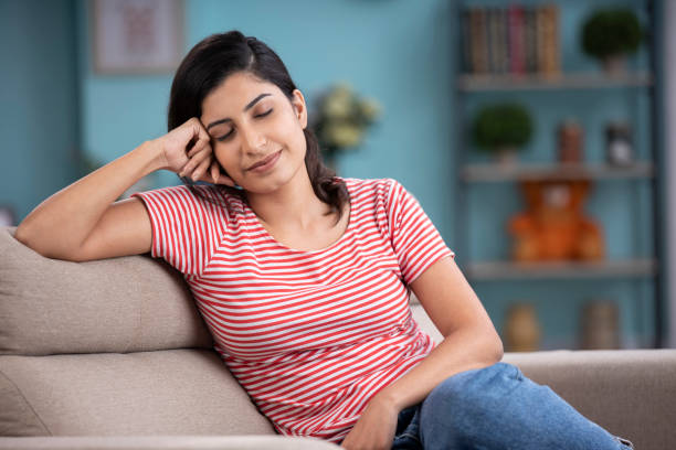 frau ruht sich auf sofa stockfoto aus - eyes closed sleeping women human face stock-fotos und bilder