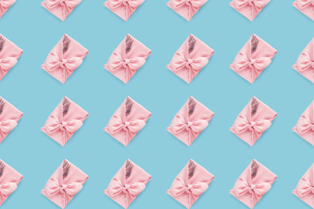 istock Pink gift pattern wrapping Japanese furoshiki style on light blue background, flat lay. 1343136244