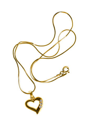 Gold necklace with heart shaped pendant isolated over white