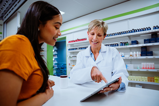 Pharmacy Drugstore: Female Pharmacist Scanning Medicine's Barcode in a Pharmacy