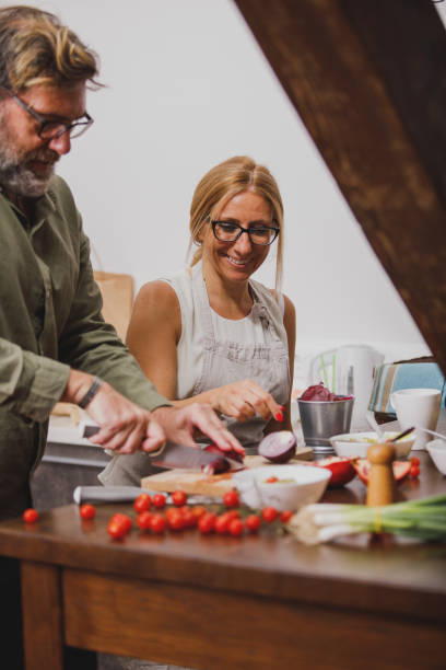 istock Cheerful mature woman preparing dinner with her husband 1343139371