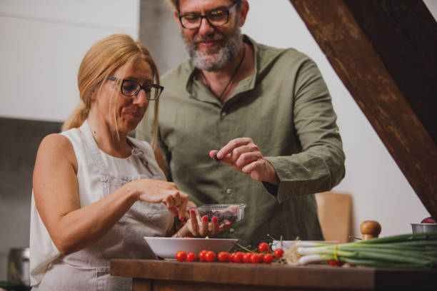 istock Mature couple adding olives to their dinner 1343139376