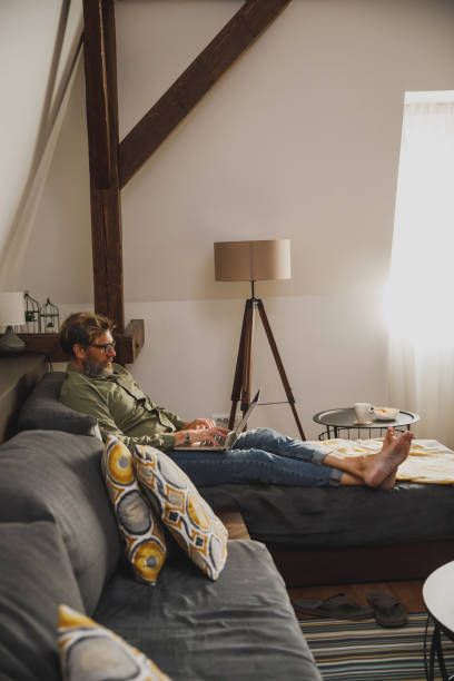 istock Mature man lounging on the sofa and catching up on some work 1343141583