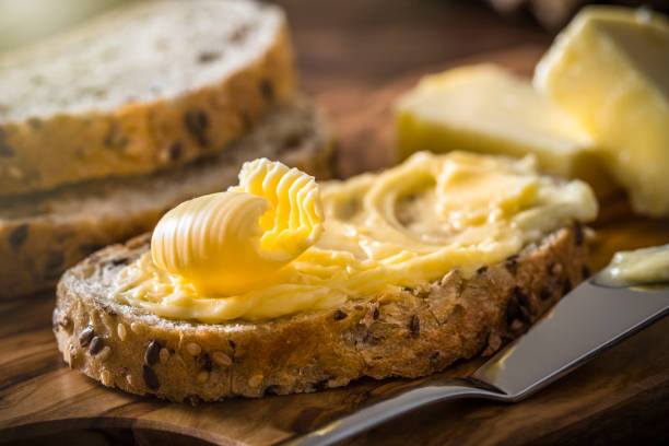 slice of bread with butter curl - margarine dairy product butter close up imagens e fotografias de stock