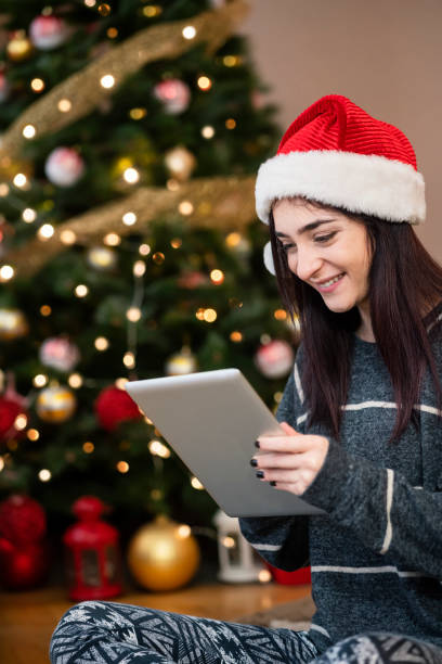 istock Young woman using digital tablet at Christmas time 1343151806