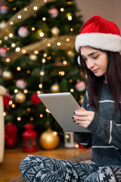 istock Young woman using digital tablet at Christmas time 1343152184