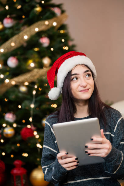istock Young woman using digital tablet at Christmas time 1343152331