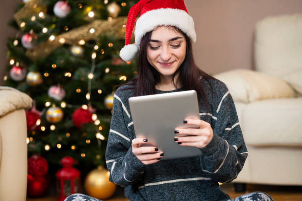 istock Young woman using digital tablet at Christmas time 1343152333