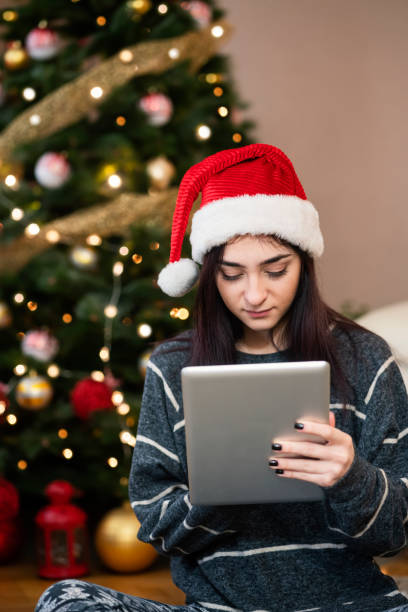 istock Young woman using digital tablet at Christmas time 1343152338
