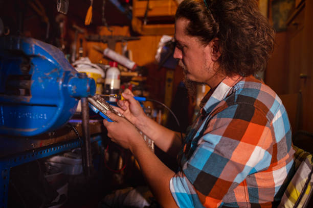 istock Focused maintenance engineer observing the motherboard he repairing in his workshop 1343153023