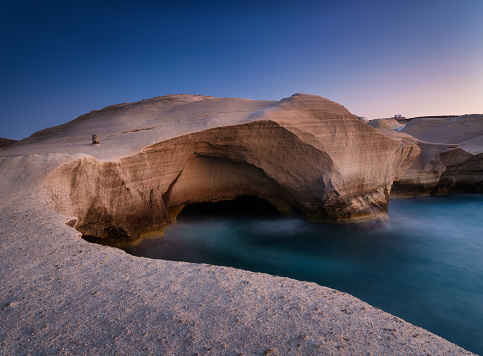 Sarakiniko beach. Milos island. Greece. A seascape during sunset. Long exposure. Rocks on the seashore. Sunlight during sunset. Natural background.