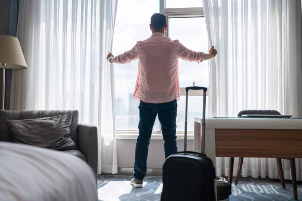 man using mobile phone i̇n hotel room - rear view back men reaching zdjęcia i obrazy z banku zdjęć