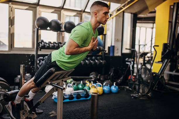 istock Young man doing hyperextension in gym 1343157433