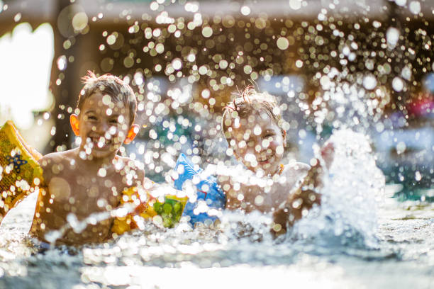 istock Happy little boys having fun while splashing water in summer day. 1343159301