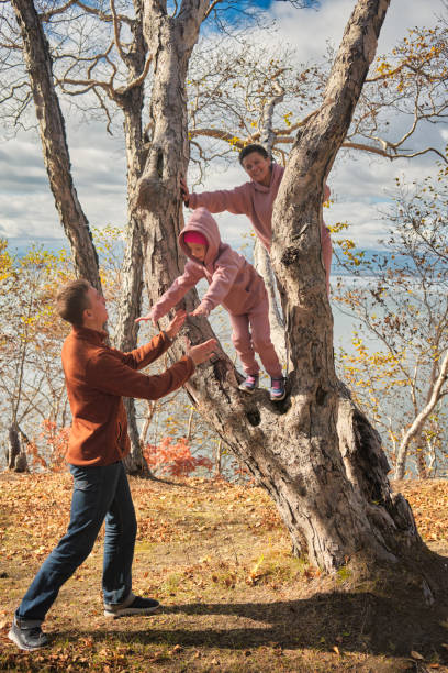 Dad catches his daughter jumping from a tree in his arms