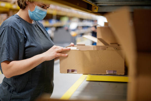 istock Female warehouse worker picking items from cardboard box 1343159508