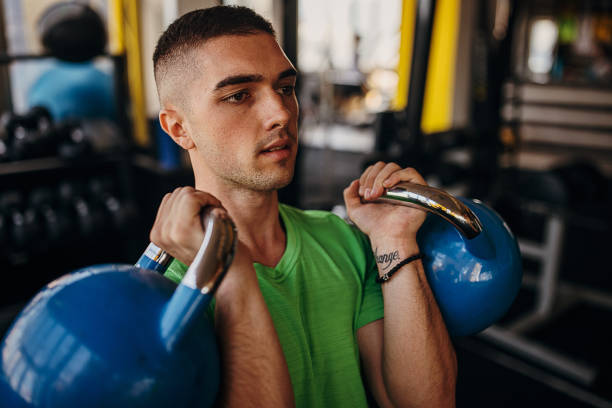 istock Man exercising with kettlebells in gym 1343161799