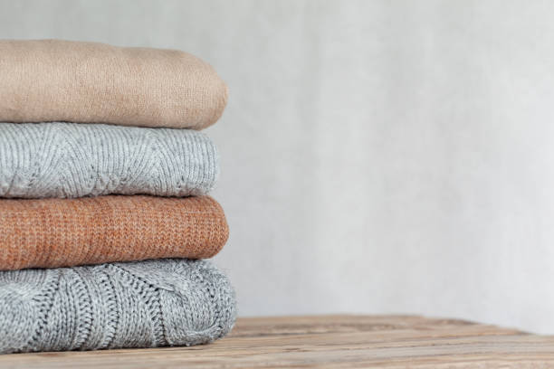 istock Pile of cozy knitted sweaters on a neutral background. Warm concept 1343164089