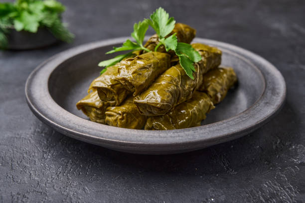 istock Delicious stuffed grape leaves, traditional Middle Eastern dish dolma or sarma, with parsley in black plate 1343171003