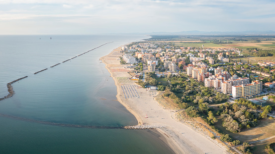 Aerial shot of sandy beach with umbrellas and town.Summer vacation concept.Lido Adriano town,Adriatic coast, Emilia Romagna,Italy.