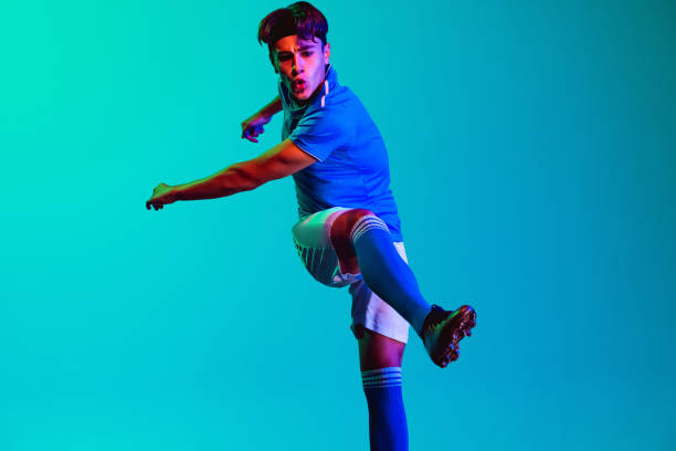 istock One profession young male football player training on blue backround 1343185707